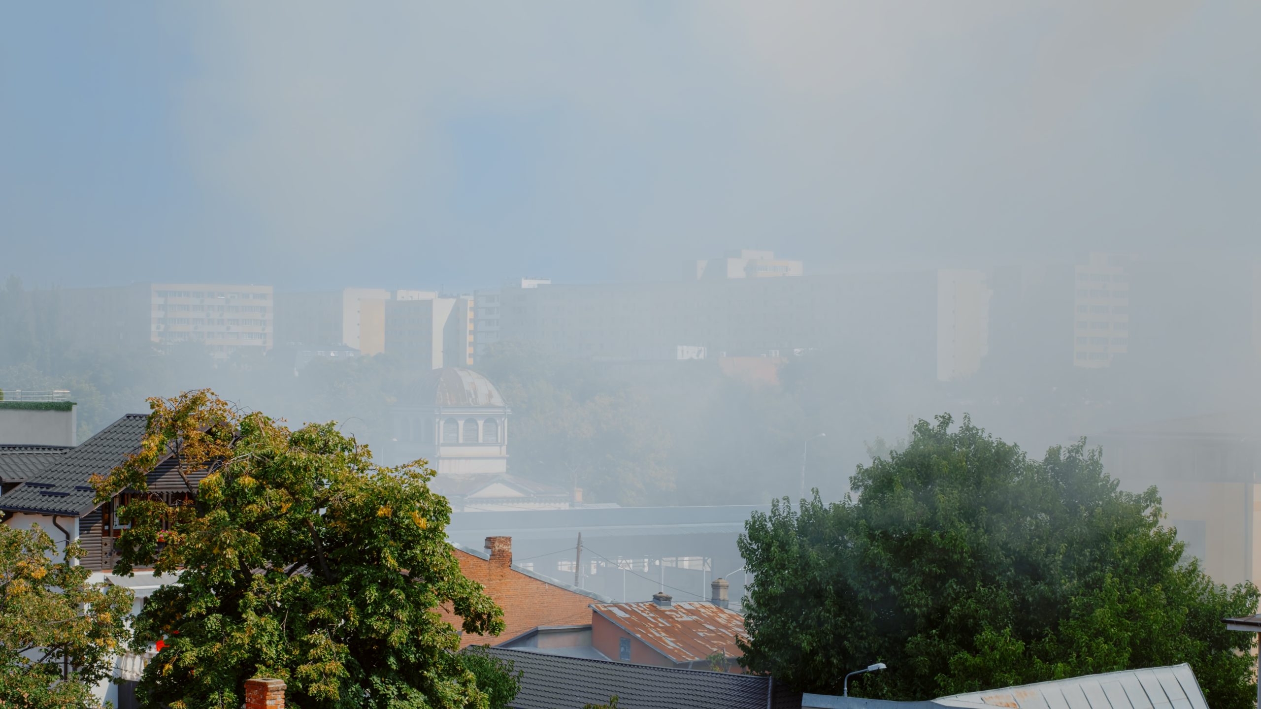 Urban landscape of city with smoke from burning house